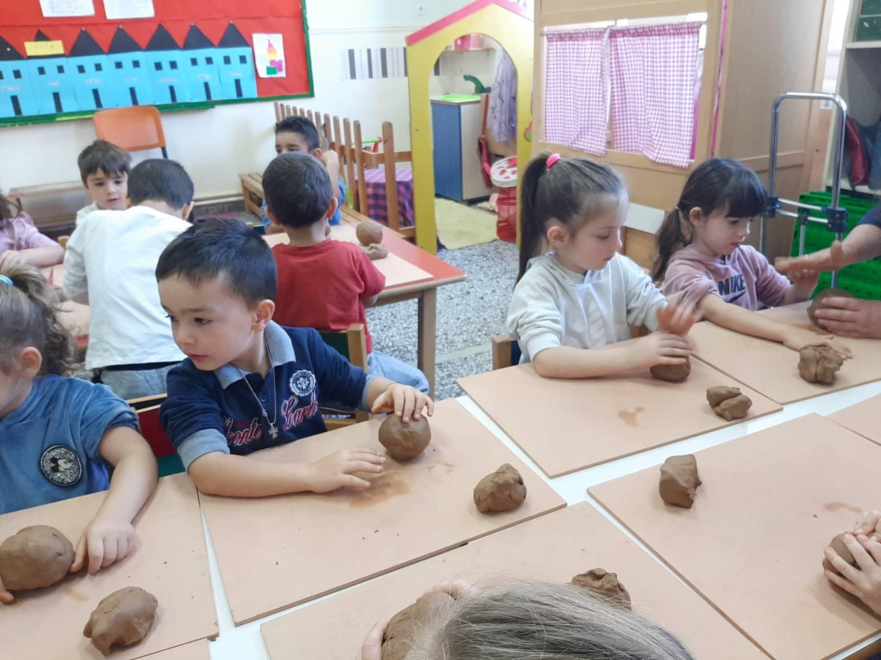 کودکان در حال بازی و سفالگری با گل در مهدکودک